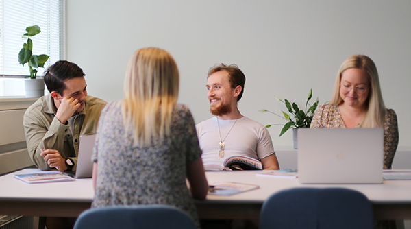 Fire mennesker omkring et arbejdsbord